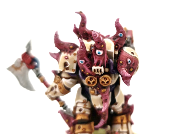 A photo showing pink tentacles with several blue eyes poking through armour plating on a chaos terminator. 