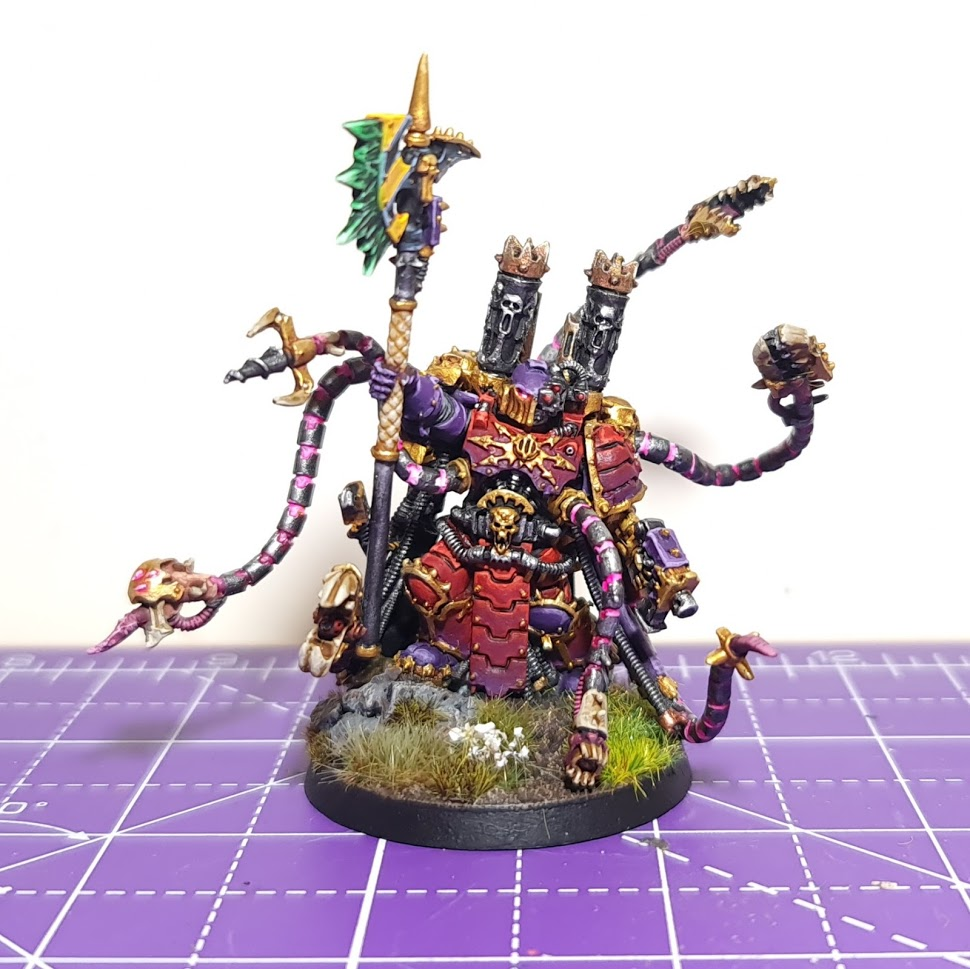 A model Warpsmith, a heavily armoured warrior with dozens of mechanical tendrils carrying tools and acting as a brightly-coloured cloak.