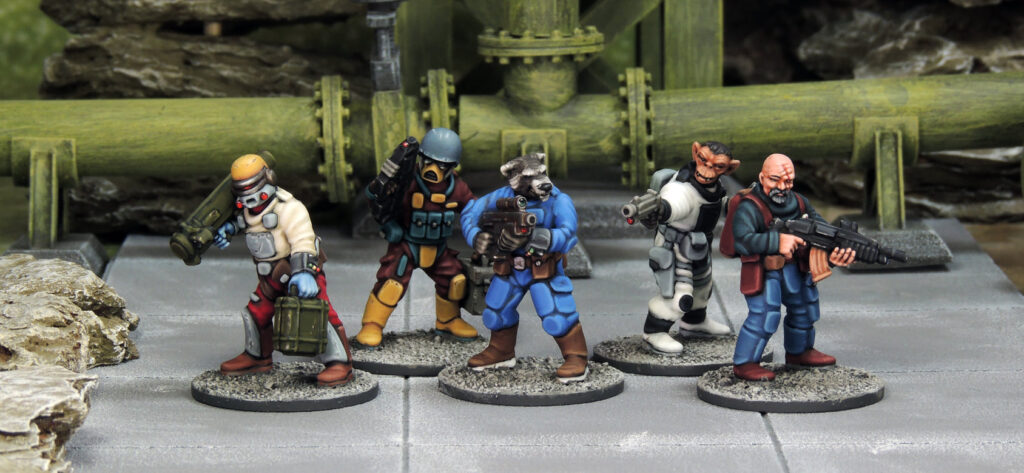 five 28mm Stargrave miniatures in a range of poses. one holds a missile launcher, one a pistol, one is a raccoon headed humanoid, one an ape and the last is a bald white man with an assault rilfle